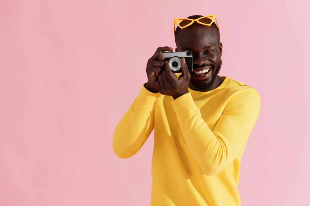 Un photographe prend une photo en souriant (illustration pour la formation Powerpoint)
